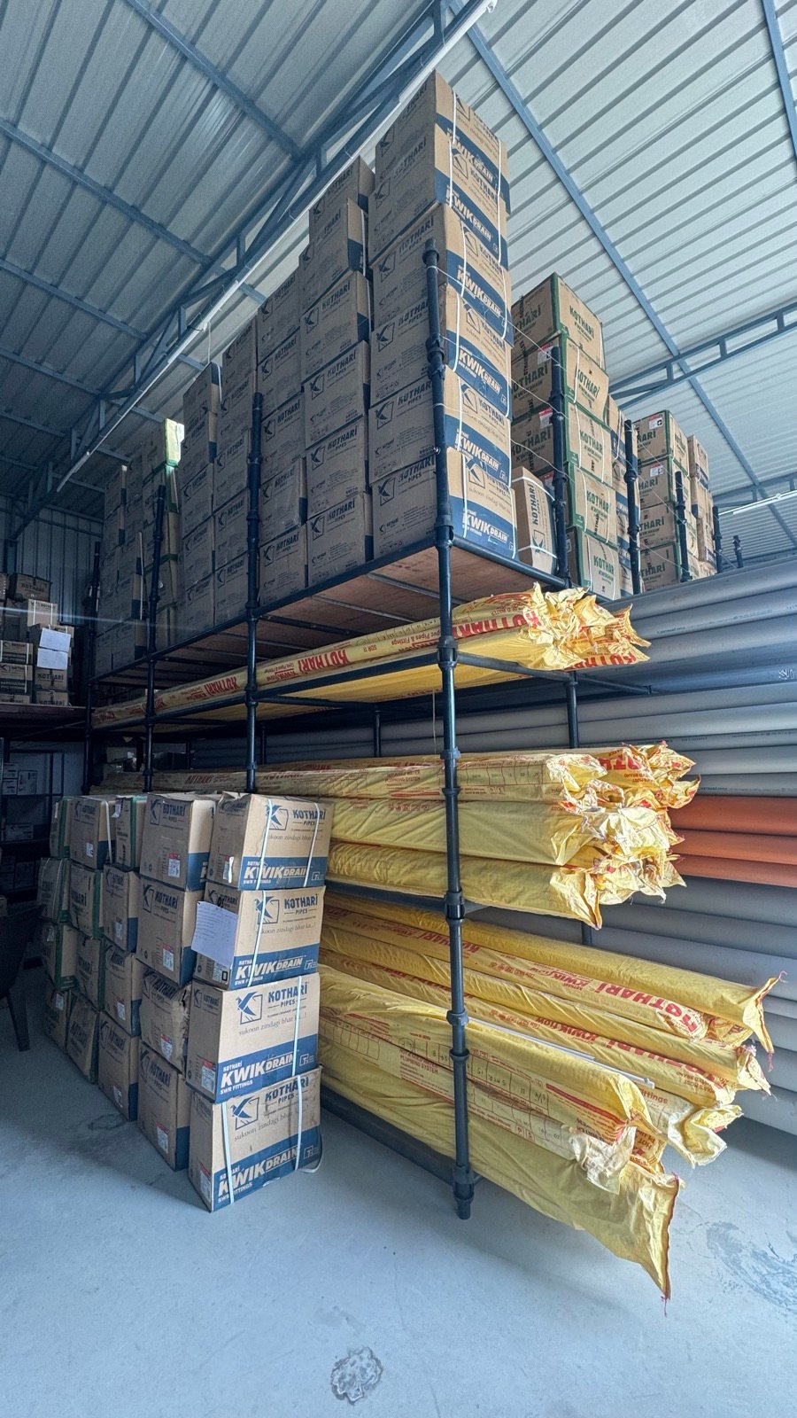 Warehouse shelving stocked with Kothari boxes and solvent cement
